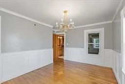 a view of a hallway with wooden floor and chandelier