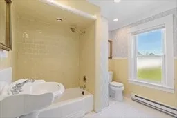 a bathroom with a bathtub shower sink and toilet
