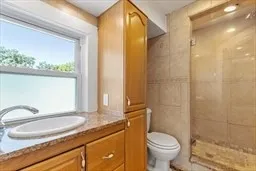 a bathroom with a granite countertop sink toilet and shower