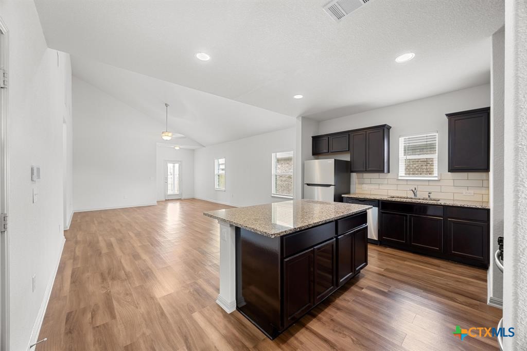 a kitchen with stainless steel appliances granite countertop a stove a sink and a microwave