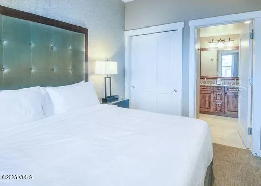 a bedroom with a large bed and a chandelier