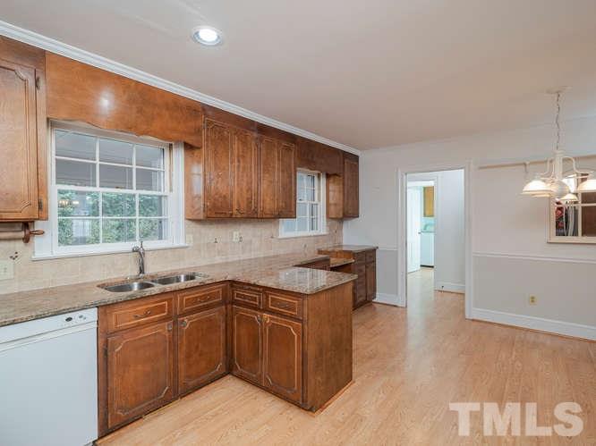 2205 Barfield Court Raleigh, NC 27612 - Photo 12 of 30 a kitchen with granite countertop a sink counter top space and cabinets