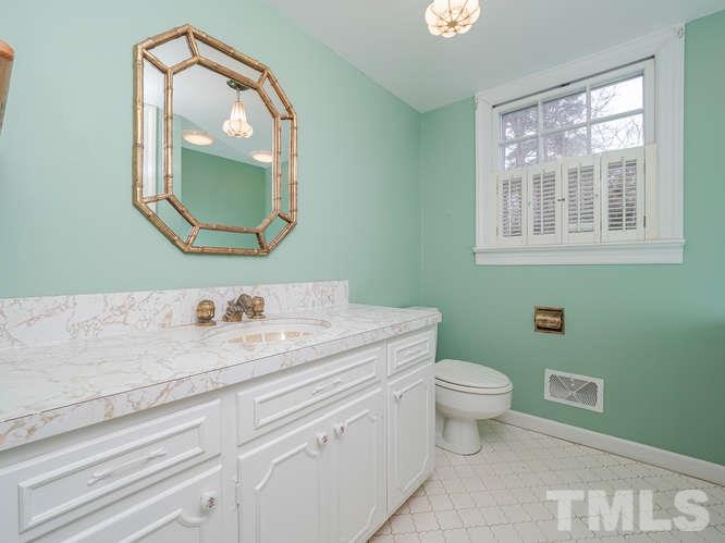 2205 Barfield Court Raleigh, NC 27612 - Photo 21 of 30 a bathroom with a toilet a sink a vanity and mirror