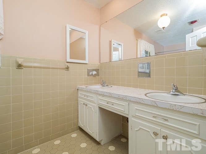 2205 Barfield Court Raleigh, NC 27612 - Photo 25 of 30 a bathroom with a granite countertop sink a mirror and a