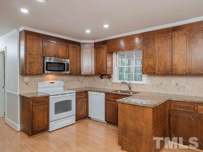 2205 Barfield Court Raleigh, NC 27612 - Photo 9 of 30 a kitchen with stainless steel appliances granite countertop wooden cabinets a sink and a stove