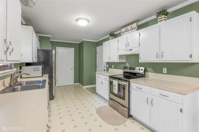 a kitchen with granite countertop a sink stove and refrigerator