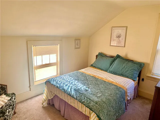 a bedroom with a bed and painting on the wall