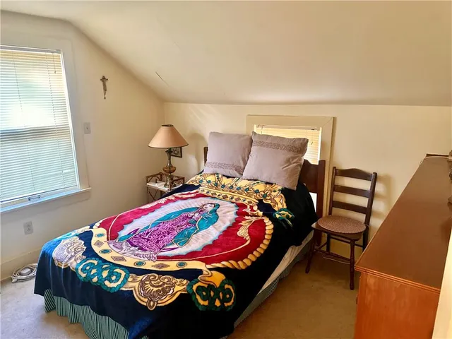 a bed sitting in a bedroom next to a window