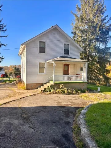 a view of a house with backyard and trees