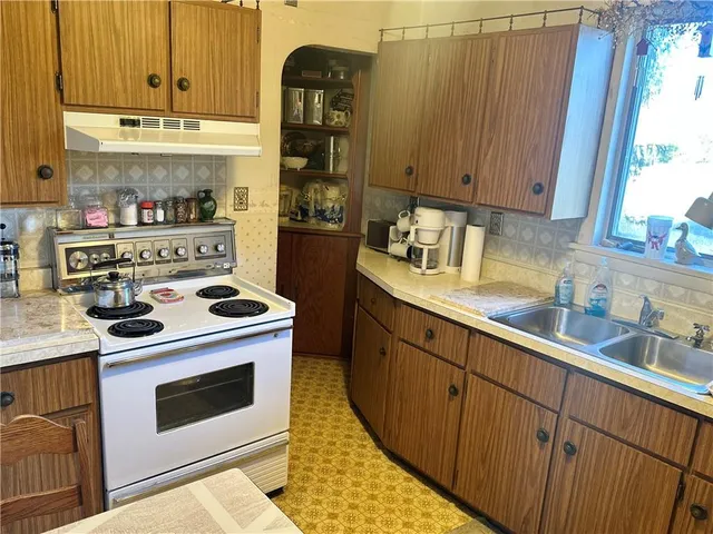 a kitchen with stainless steel appliances a stove a sink a refrigerator and cabinets