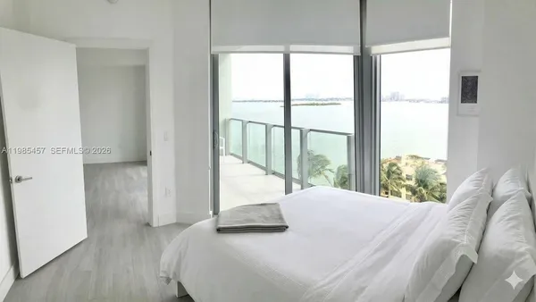 a bedroom with a bed and a large window