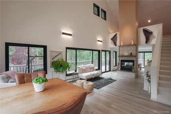a living room with furniture large window and wooden floor
