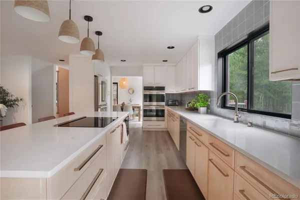 a large kitchen with a large window and stainless steel appliances