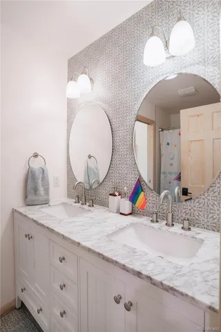 a bathroom with double vanity sinks and a mirror