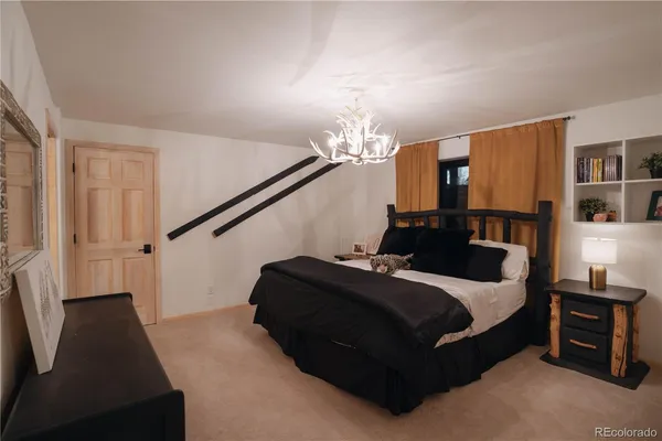 a living room with a bed furniture and a chandelier
