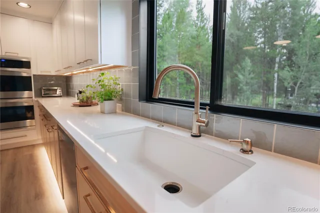 a bathroom with a granite countertop sink and a large mirror
