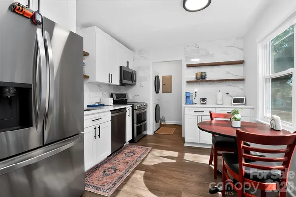 a kitchen with stainless steel appliances kitchen island granite countertop a refrigerator and a stove top oven