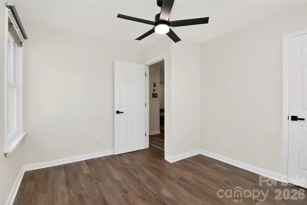 a view of an empty room with wooden floor