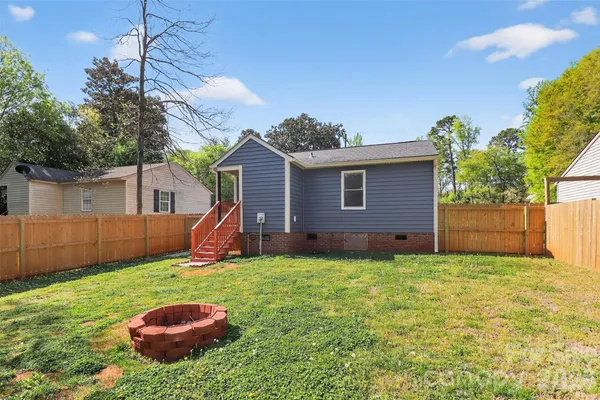 a view of a backyard with table and chairs and potted plants