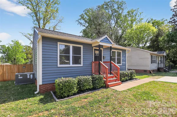 a view of a house with backyard and a tree