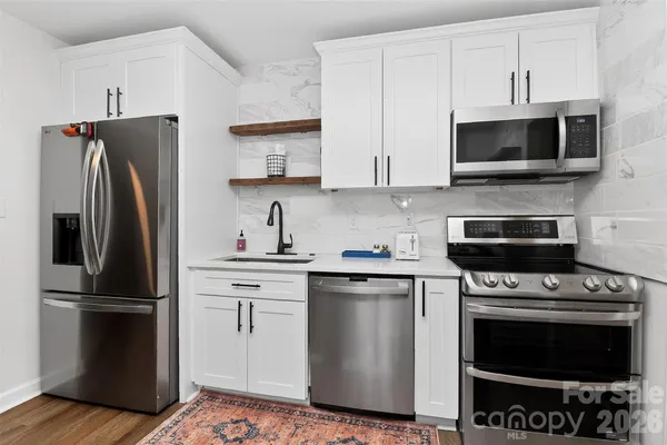 a kitchen with stainless steel appliances a stove a microwave and a refrigerator