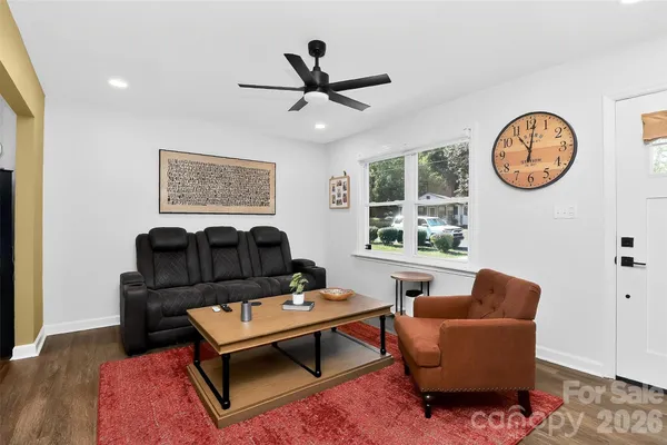 a living room with furniture a window and a clock