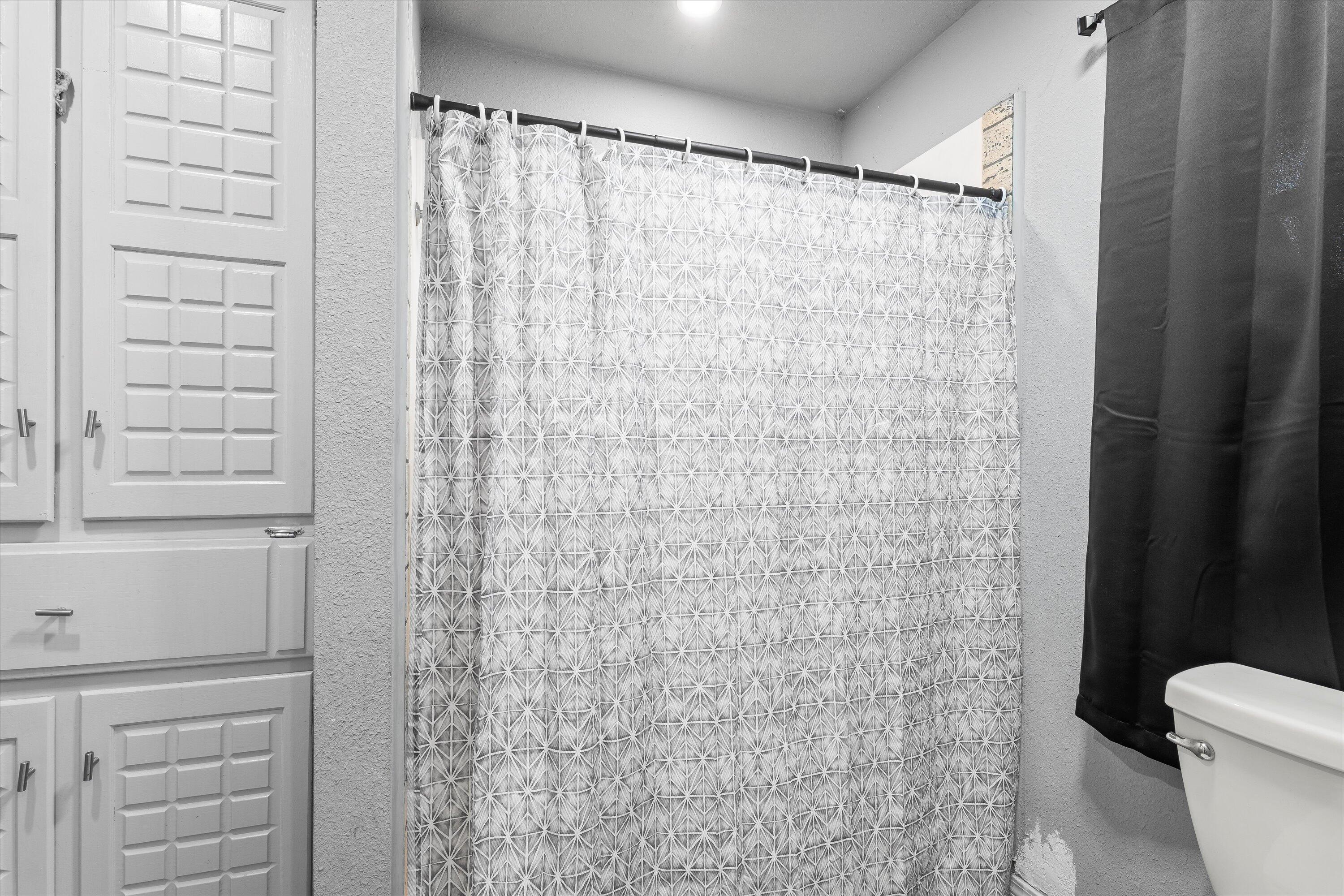 3718 South State Road, Unit 303 Sundown, TX 79372 - Photo 14 of 23 a bathroom with a shower curtain and a toilet
