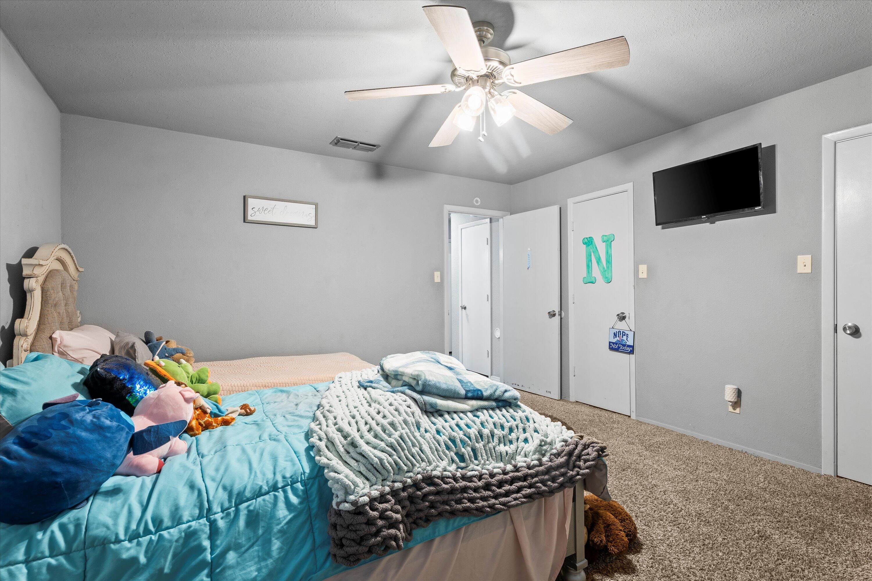 3718 South State Road, Unit 303 Sundown, TX 79372 - Photo 18 of 23 a bedroom with a bed and a chandelier