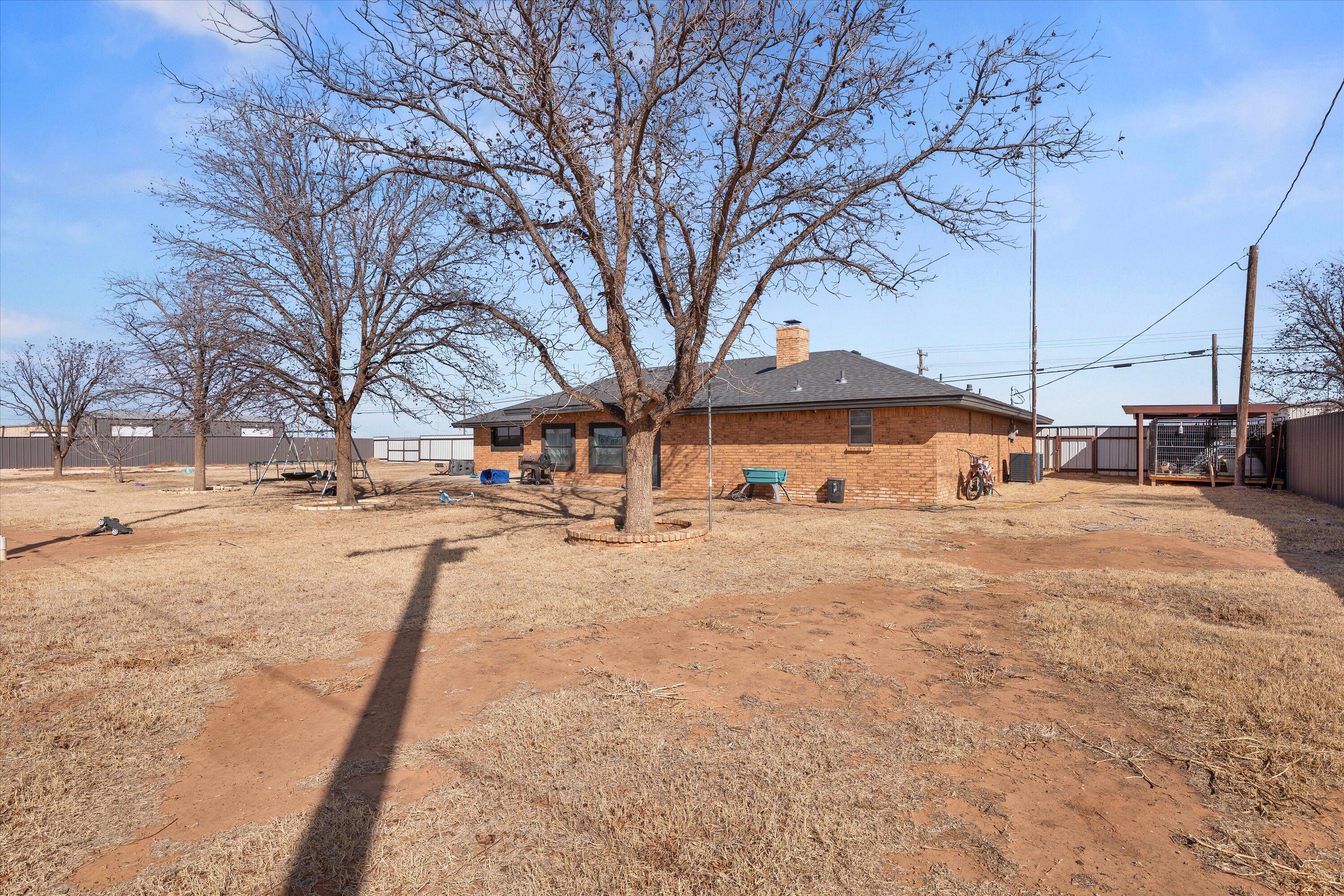 3718 South State Road, Unit 303 Sundown, TX 79372 - Photo 21 of 23 a yellow house with trees in front of it