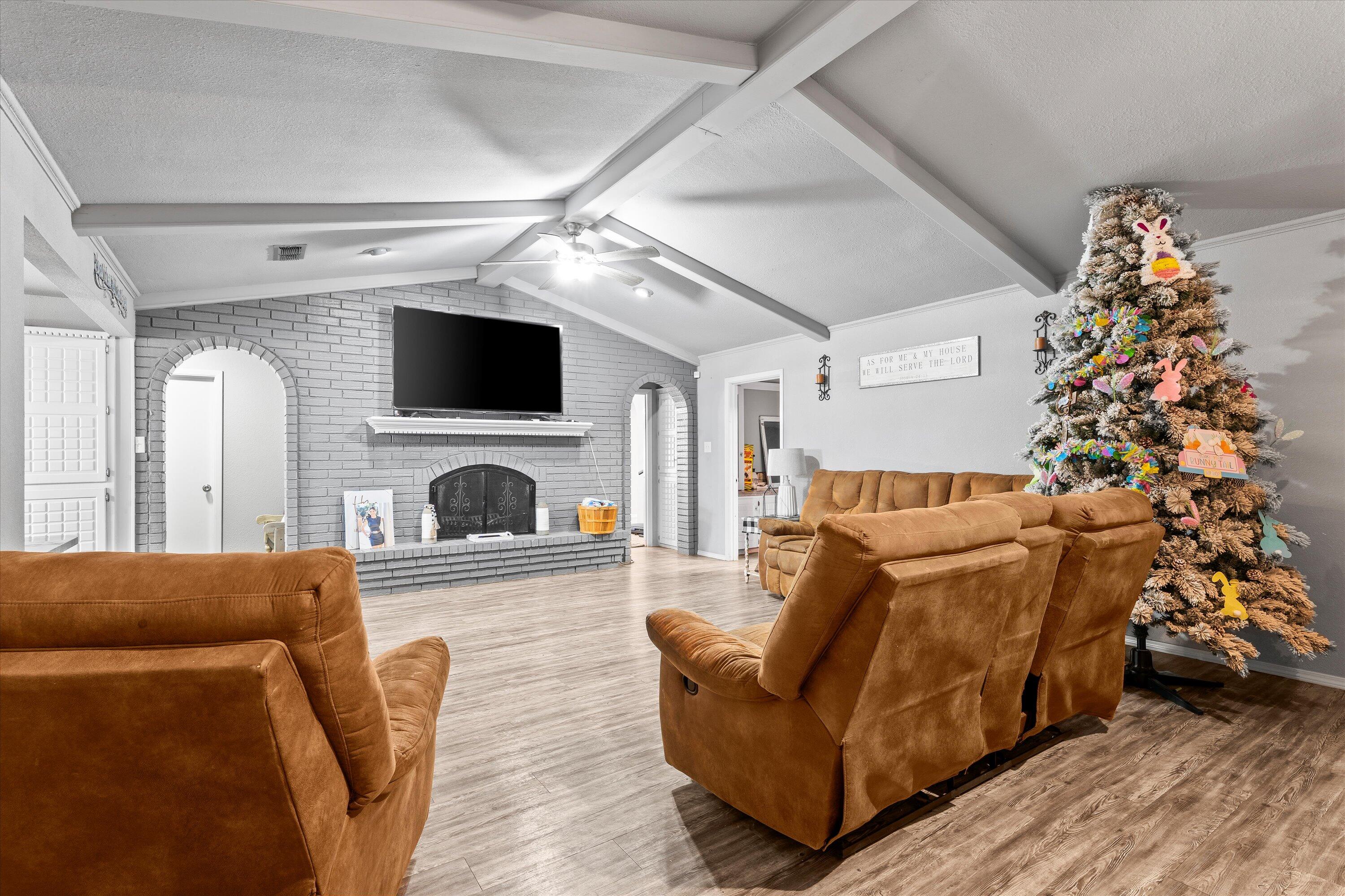 3718 South State Road, Unit 303 Sundown, TX 79372 - Photo 4 of 23 a living room with furniture a flat screen tv and a fireplace