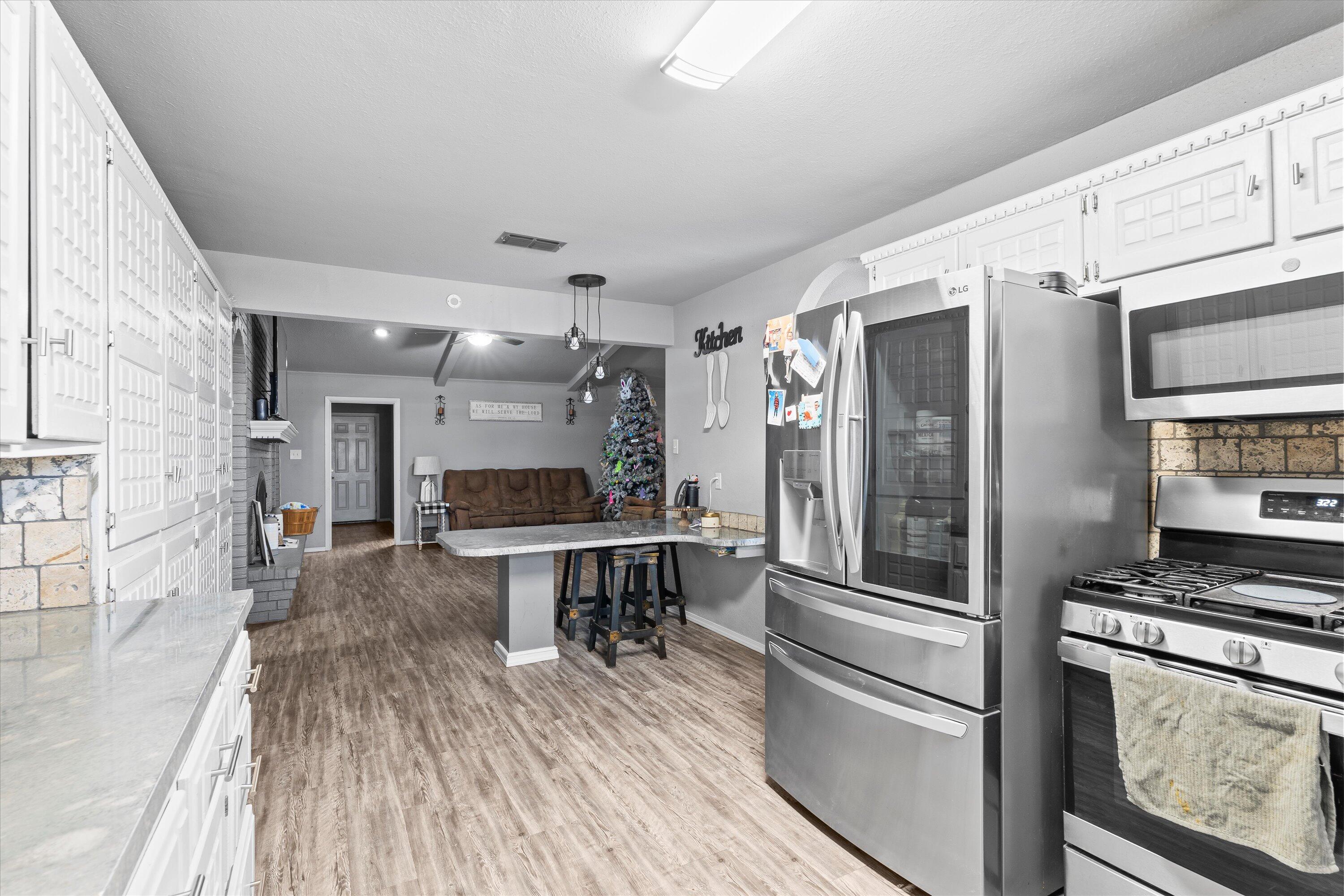 3718 South State Road, Unit 303 Sundown, TX 79372 - Photo 9 of 23 a kitchen with stainless steel appliances a refrigerator and a stove top oven