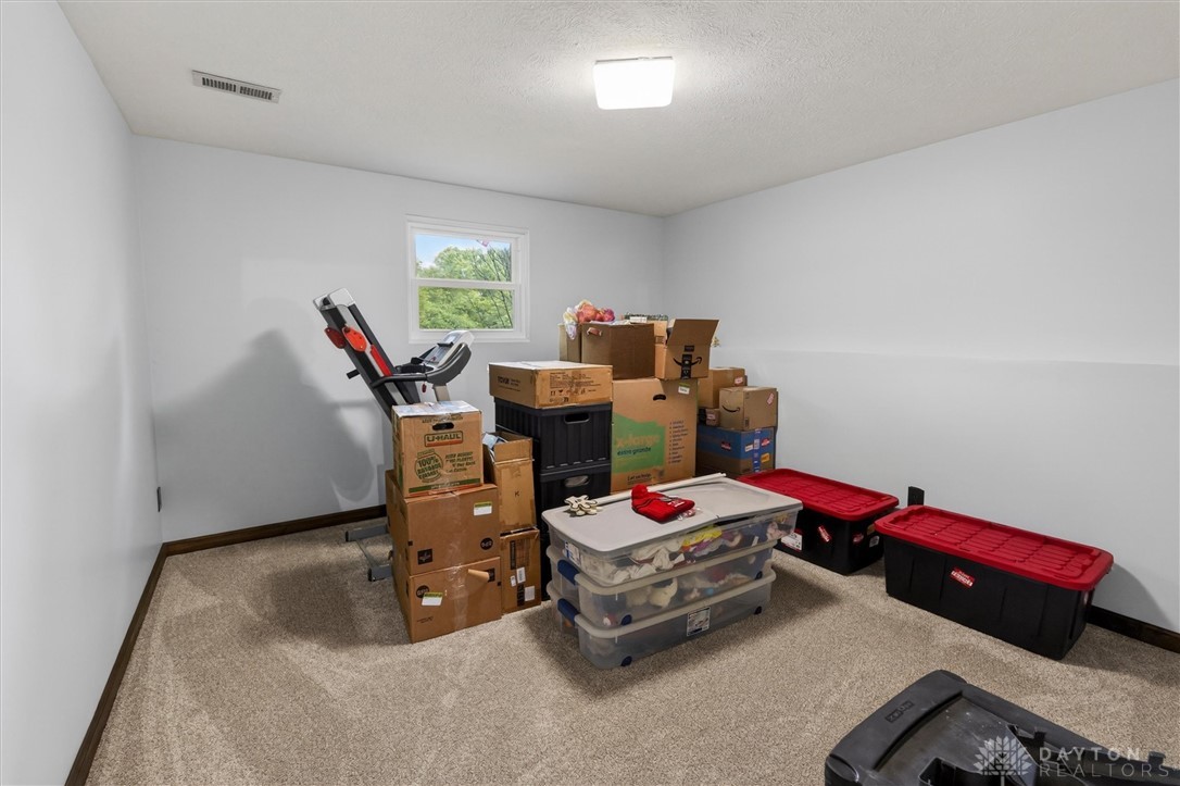 2165 Stewart Road Xenia, OH 45385 - Photo 23 of 59 This spacious room features a large window and plush carpeting, offering versatile use.