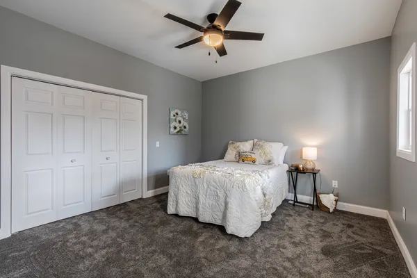 a bedroom with a bed and a ceiling fan