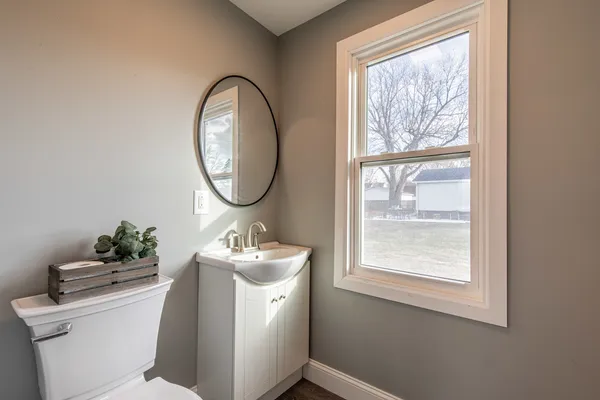 a bathroom with a toilet sink mirror and vanity