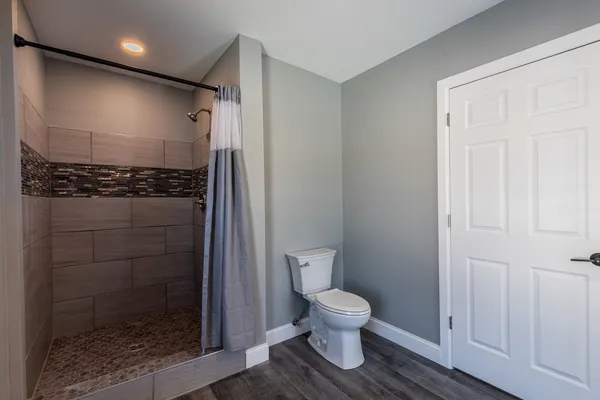 a bathroom with a toilet and a shower