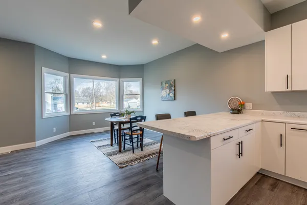 a open kitchen with stainless steel appliances granite countertop a stove and a wooden floors