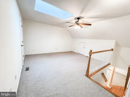 a view of an empty room with a chandelier fan