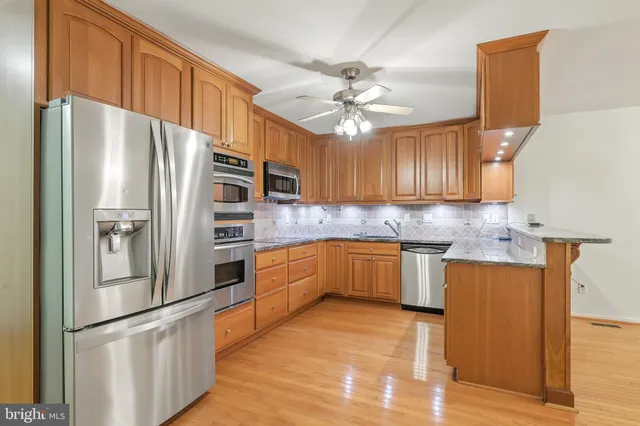 a kitchen with stainless steel appliances granite countertop a sink and cabinets