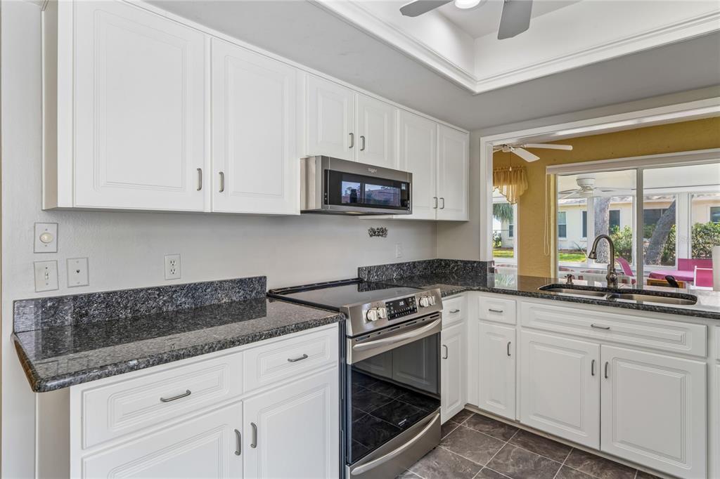 2252 Pebble Beach Drive Spring Hill, FL 34606 - Photo 12 of 100 a kitchen with stainless steel appliances granite countertop white cabinets granite counter tops and a wooden floors
