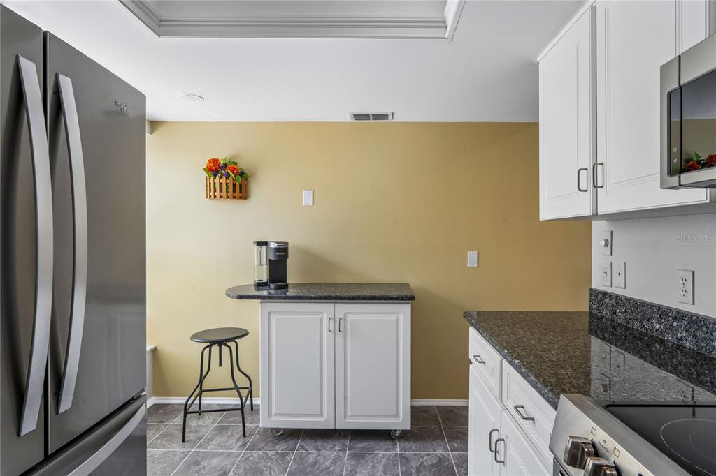 2252 Pebble Beach Drive Spring Hill, FL 34606 - Photo 14 of 100 a kitchen with stainless steel appliances granite countertop a refrigerator a sink a stove and white cabinets