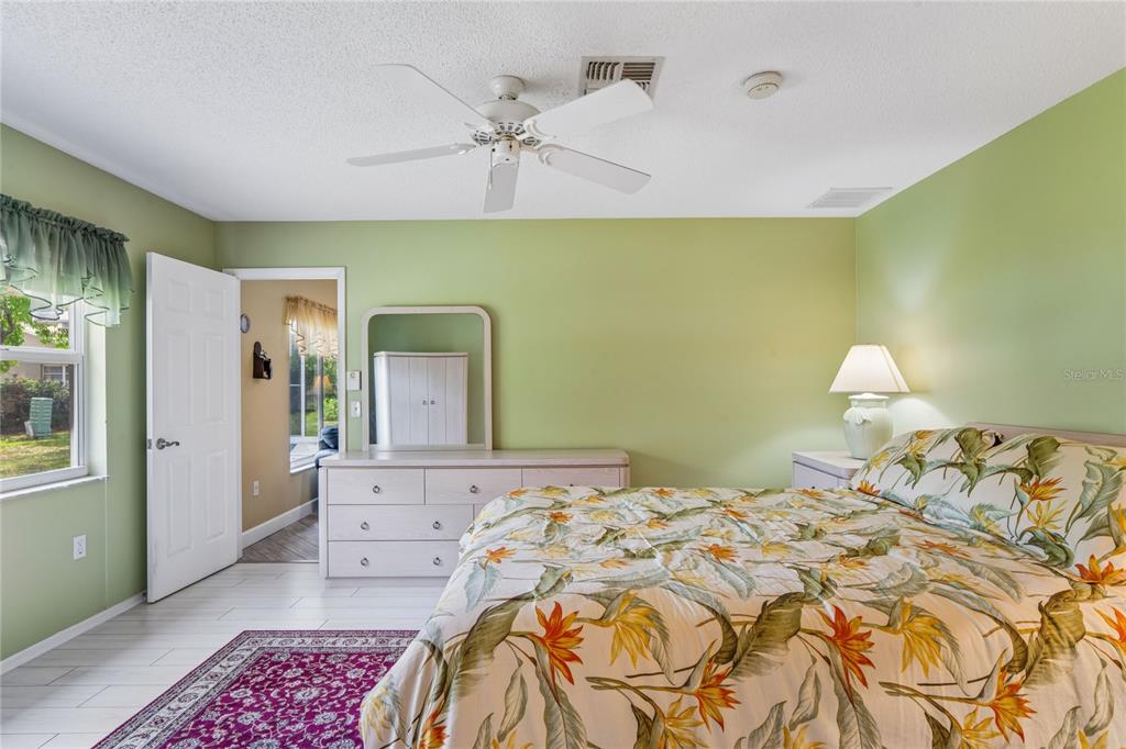 2252 Pebble Beach Drive Spring Hill, FL 34606 - Photo 20 of 100 a bedroom with a bed and a chandelier