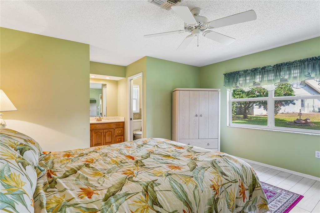 2252 Pebble Beach Drive Spring Hill, FL 34606 - Photo 21 of 100 a bedroom with a bed and a chandelier
