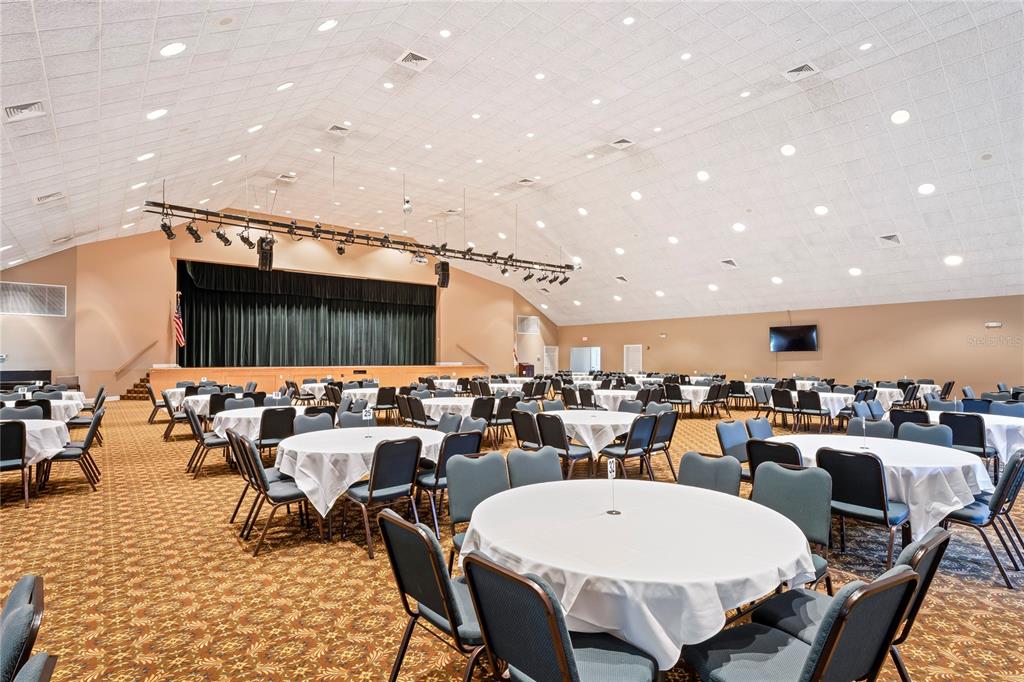 2252 Pebble Beach Drive Spring Hill, FL 34606 - Photo 63 of 100 a large room with lots of tables a large window and chairs