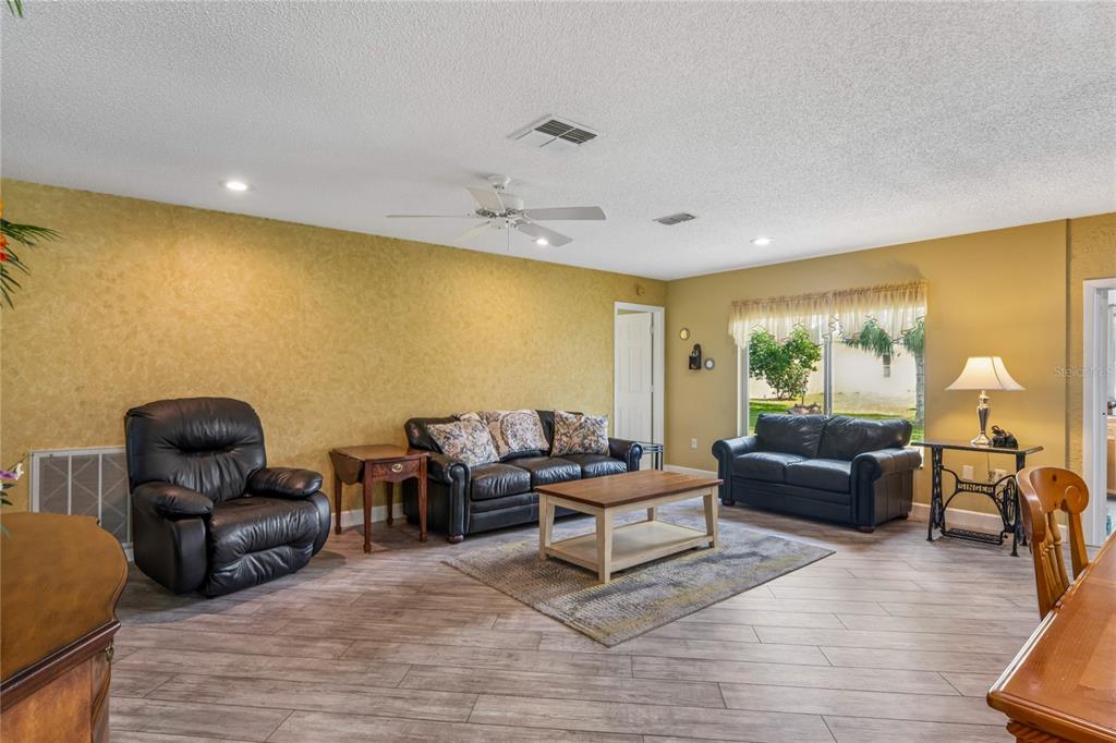 2252 Pebble Beach Drive Spring Hill, FL 34606 - Photo 8 of 100 a living room with furniture and a wooden floor