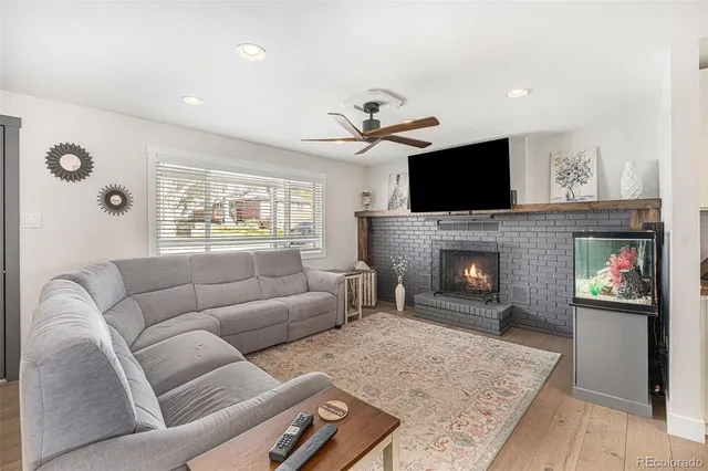 a living room with furniture a flat screen tv and a fireplace