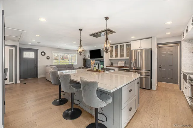 a kitchen with stainless steel appliances a table chairs refrigerator and sink