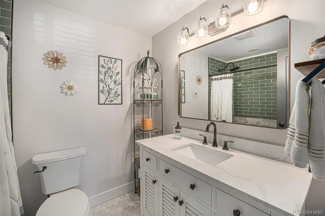 a bathroom with a sink vanity granite and toilet