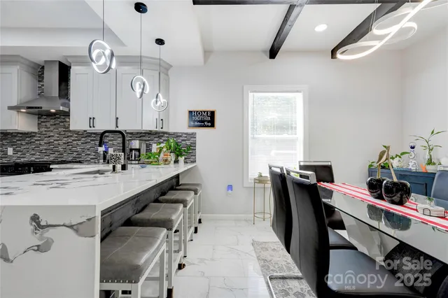 a kitchen with stainless steel appliances kitchen island granite countertop a sink a stove and a dining table