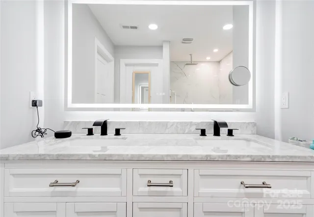 a bathroom with double sink and a mirror