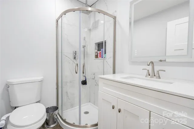 a bathroom with a granite countertop sink mirror vanity and toilet